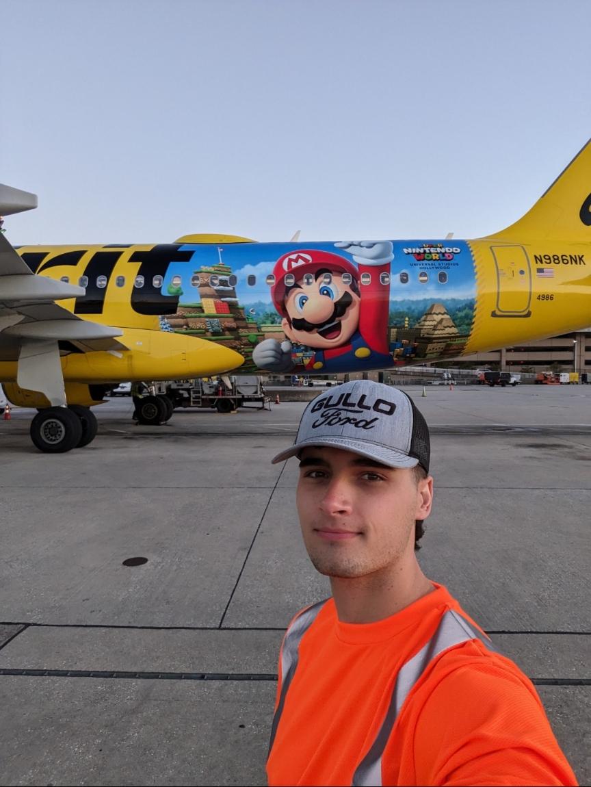 Bradley Shipes standing in front of a Spirit Airlines aircraft on the tarmac